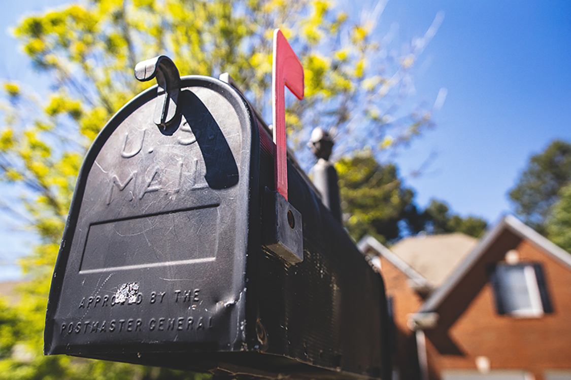 Photo of a mail box in front of a house